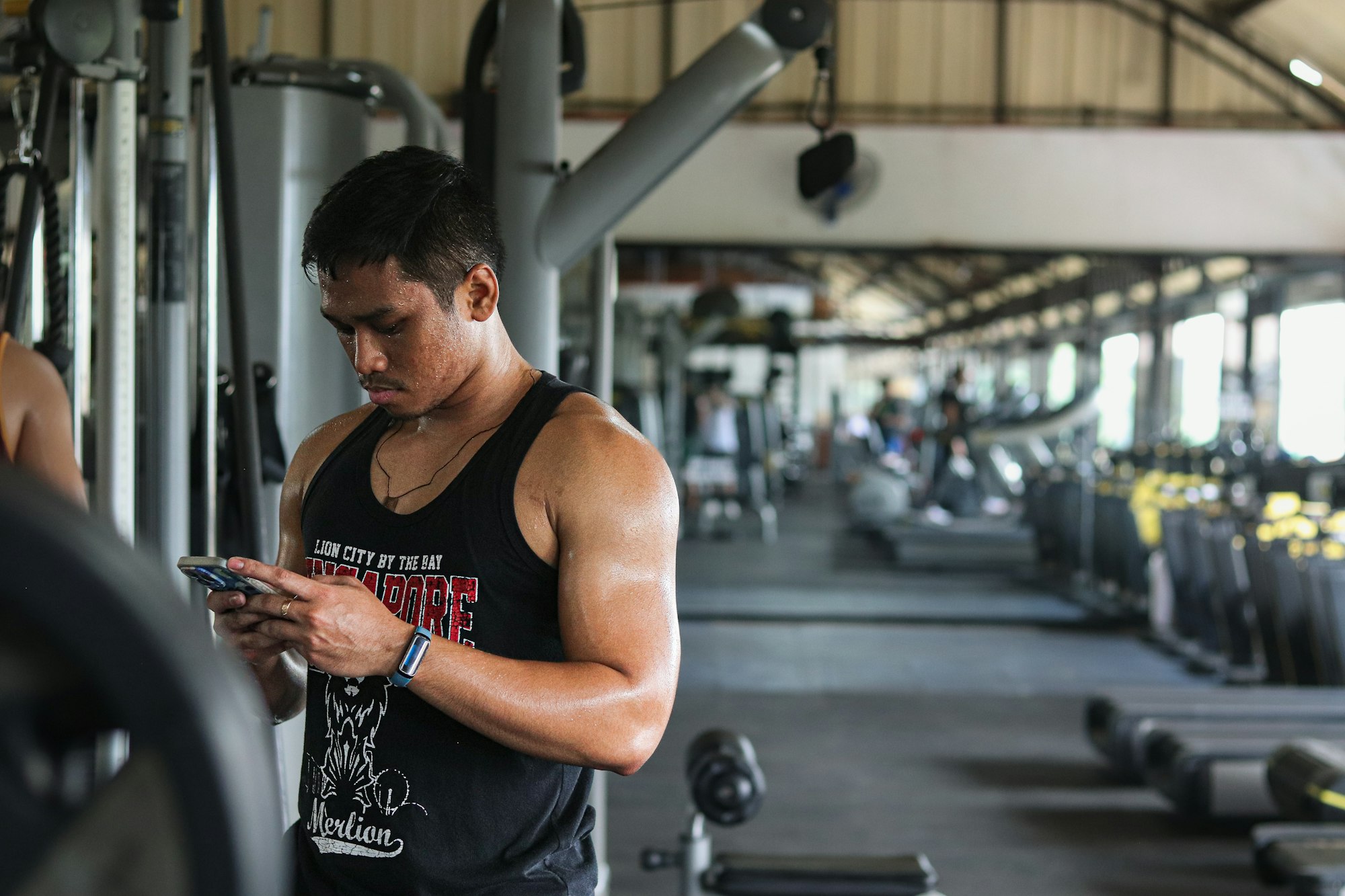 Gym member looking at his phone in a gym